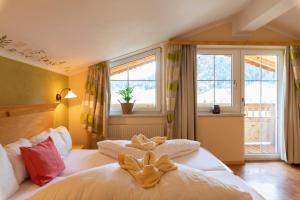 a bedroom with two beds and two windows at Residenz Theresa in Söll