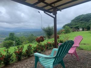 dwa krzesła ogrodowe siedzące pod pergolą z widokiem w obiekcie Disfruta del contacto con la naturaleza w mieście Puntarenas