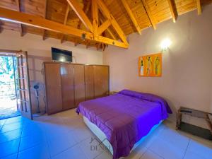 a bedroom with a purple bed in a room at Casa Tinta Roja 1 in Villa Gesell