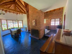 sala de estar con pared de ladrillo y chimenea en Casa Tinta Roja 1 en Villa Gesell