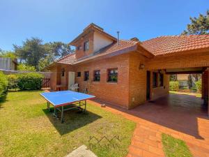 una mesa de ping pong en el patio de una casa en Casa Tinta Roja 1 en Villa Gesell