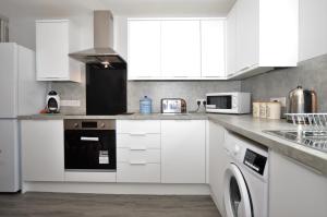 a kitchen with white cabinets and a stove top oven at Anchor View in Ardrishaig