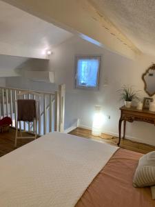 Schlafzimmer mit einem Bett, einem Tisch und einem Fenster in der Unterkunft petite maison cosy avec exterieur in Marseille