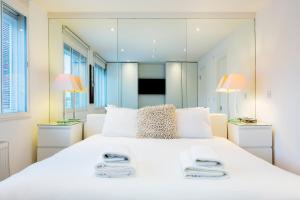 ein Schlafzimmer mit einem großen weißen Bett mit Spiegeln in der Unterkunft Veeve - Village Virtuosity in London