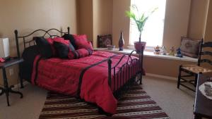 a bedroom with a bed with a red blanket and a window at The perfect place . . . here it is! in Las Cruces