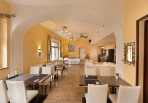 a dining room with tables and white chairs at Hotel Goldenes Lamm in Idstein
