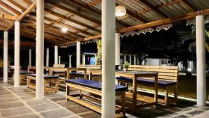 een restaurant met houten tafels en blauwe banken bij Vibes and Tides Beach Resort by Enlightened Vagabond in Gokarna