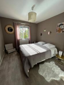 a bedroom with a large bed and a window at Maison de vacances avec piscine in Chancelade