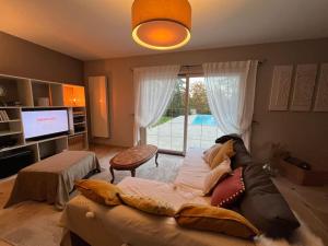 a living room with a couch and a television at Maison de vacances avec piscine in Chancelade