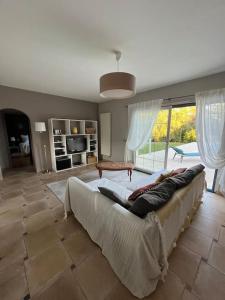uma sala de estar com um sofá e uma grande janela em Maison de vacances avec piscine em Chancelade