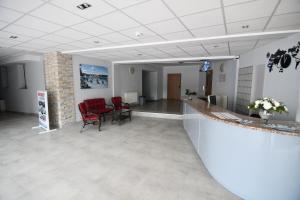 a waiting room with red chairs and a counter at Ośrodek Chrobry in Pokrzywna