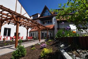 a garden in front of a house with a wooden pergola at Ośrodek Chrobry in Pokrzywna