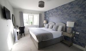 a bedroom with a large bed with a blue wall at The Binsted Inn in Alton