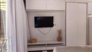 uma sala de estar com uma televisão na parede em Villas do Pratagy Jambo I com Jacuzzy em Maceió