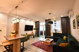 uma sala de estar com um sofá verde e uma mesa em Green Penthouse em Grudziądz