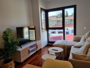 a living room with a couch and a flat screen tv at 604B - Apartamento con garaje in Oviedo