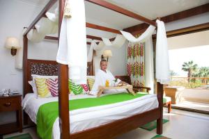 a woman sitting on a bed in a bedroom at Gafy Resort Aqua Park in Sharm El Sheikh