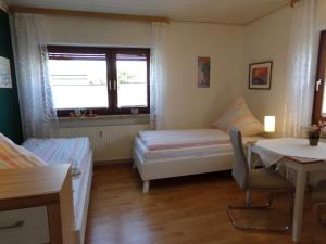 Zimmer mit einem Bett, einem Tisch und einem Fenster in der Unterkunft Ederauenblick in Dodenau