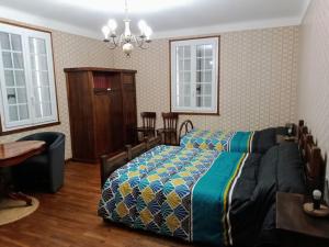 a bedroom with a bed and a table and windows at La POSADA in Ibos