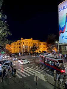 a busy city street with a bus and cars at night at Grand Royal in Belgrade