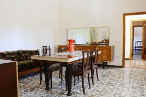 a dining room with a table and chairs and a couch at Villa Mostallino in Assemini