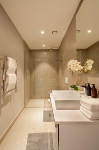 a bathroom with a sink and a shower at Greenpoint Designer Apartment near Stadium & Waterfront in Cape Town