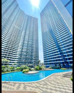 two tall buildings with a swimming pool in front of them at Marivic's Place in Manila