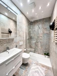 een badkamer met een wastafel, een toilet en een douche bij Green Penthouse in Grudziądz
