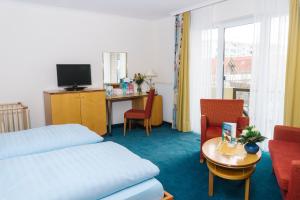 a hotel room with a bed and a table and a desk at Aparthotel Kachelot in Borkum