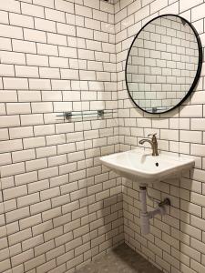Baño de azulejos blancos con lavabo y espejo en KohLan Hansa en Ko Larn