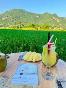a table with a drink and a plate of food at Green Homestay Mai Chau in Mai Chau