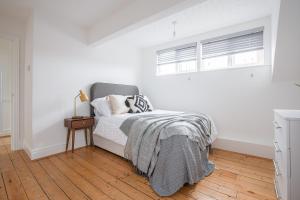 a white bedroom with a bed and a window at Charles Alexander Short Stay - Hove Suite in Lytham St Annes