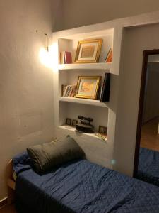 um quarto com uma cama e prateleiras com livros em BnB Convalis em Palermo