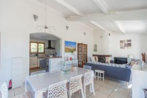 Villa Cécile في دراجوينا: مطبخ وغرفة معيشة مع طاولة وكراسي