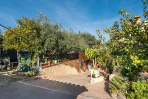 um jardim com árvores e um pátio de tijolos em Villa Gianna - Appartamento Toscano em Quartu SantʼElena
