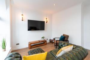 ein Wohnzimmer mit einem Sofa und einem TV in der Unterkunft Bissets Bond in Dundee