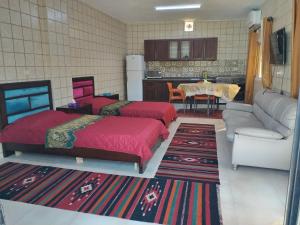 a living room with two beds and a kitchen at Greek Villa in Jerash