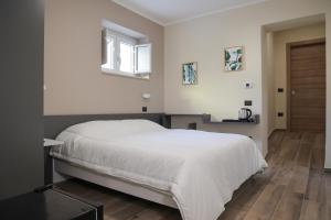 a bedroom with a white bed and a wooden floor at Lvna Telesia in Telese