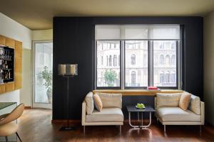 a living room with two chairs and a window at DO&CO Hotel Vienna in Vienna