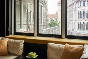 a room with a large window with a couch and a table at DO&CO Hotel Vienna in Vienna