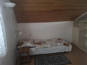 a small bed in a room with a wooden ceiling at Ubytovanie v sukromi in Dolní Bzince