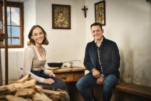 a man and a woman sitting on a wooden bench at Hotel Pettneuerhof in Pettneu am Arlberg