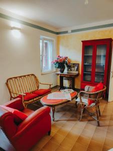 sala de estar con muebles de color rojo y mesa en B&B Al Giardino dei Laghi, en Revine Lago