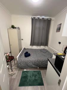 a small bedroom with a bed and a table at Lovely apartment close to Acton central station in London