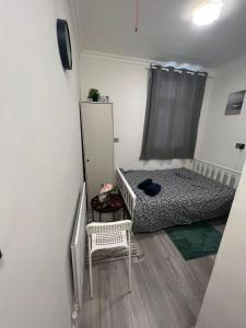 a small bedroom with a bed and a chair at Lovely apartment close to Acton central station in London