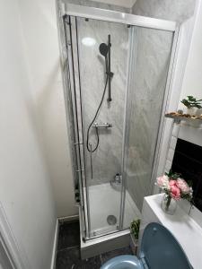 a shower stall in a bathroom with a blue toilet at Lovely apartment close to Acton central station in London