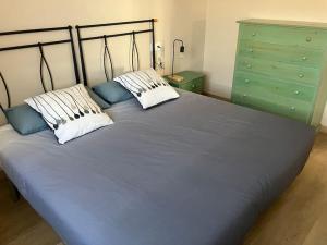 1 cama azul con 2 almohadas y cómoda verde en A Casa da Fonte, en Santa Eulalia de Oscos