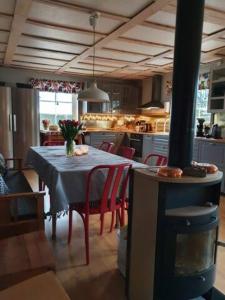 a kitchen with a table with red chairs and a dining room at Lillesjö stuguthyrning in Bäckefors