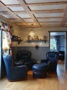 a living room with chairs and a couch and a ceiling at Lillesjö stuguthyrning in Bäckefors