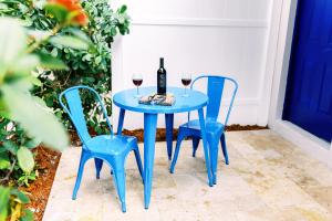 uma mesa azul com duas cadeiras e uma garrafa de vinho em Casa Cordova By Lowkl em Fort Lauderdale